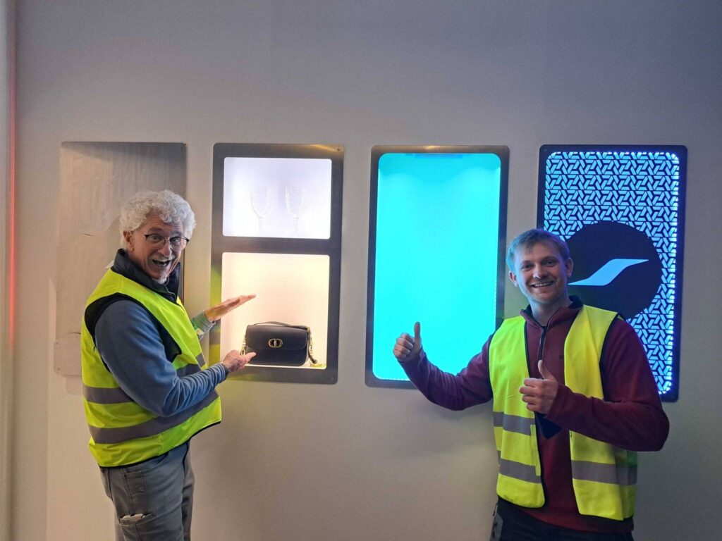 STG Aerospace team demonstrating illuminated cabin lighting panels showcasing The Curve flexible lighting system